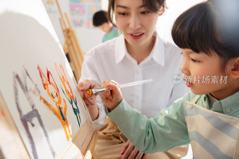 青年女人教小朋友画画