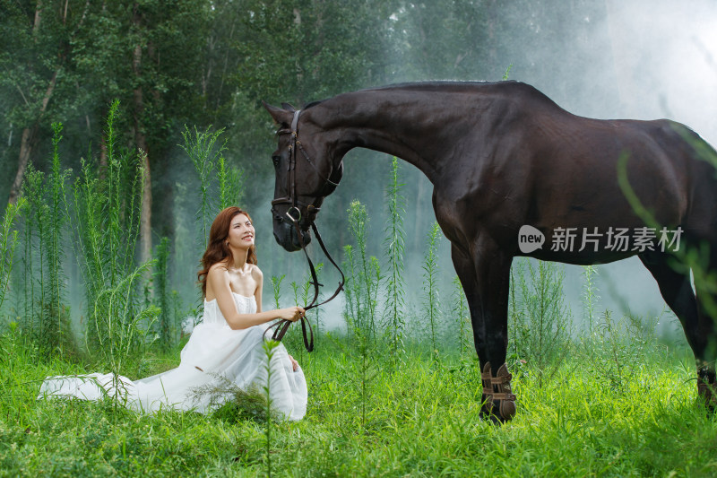 草地上漂亮的青年女人和马