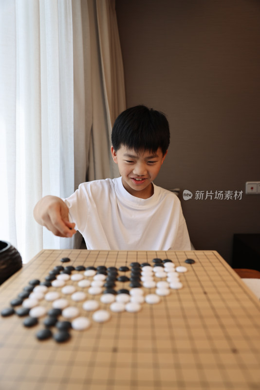 可爱的男孩在窗边下围棋