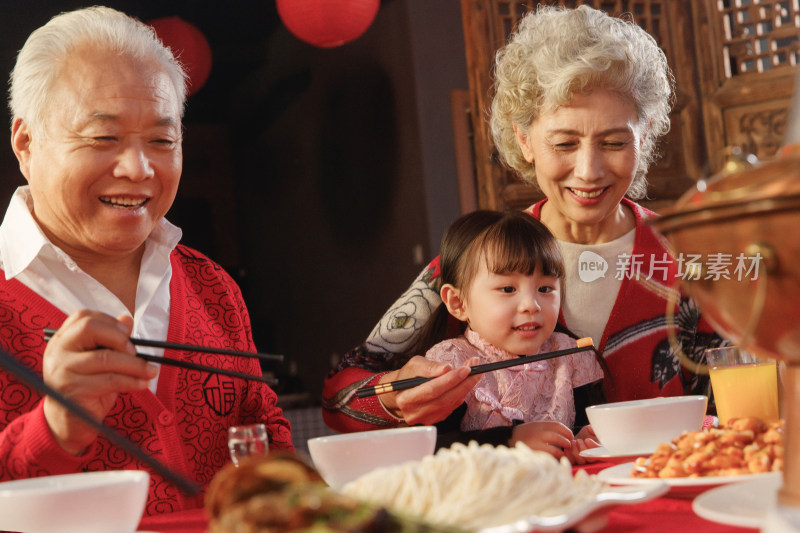 幸福的祖父母和孙女用餐