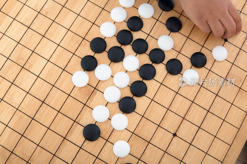 俯视拍摄棋盘上小孩子的手在摆放围棋棋子