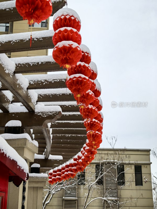 挂满雪的建筑上挂着一串红灯笼