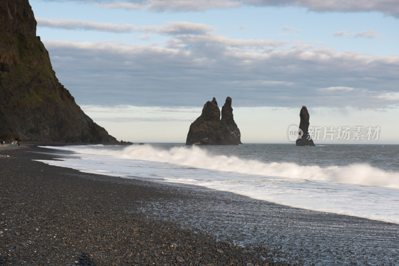 黑沙滩海浪与海中岩石景观