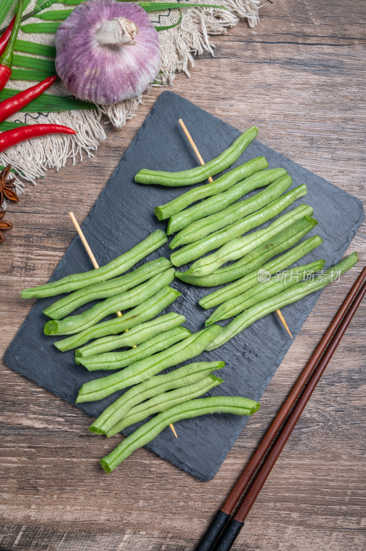 石板上串好的新鲜豆角串