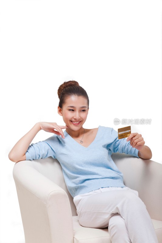 年轻女人坐在沙发上拿着电话卡