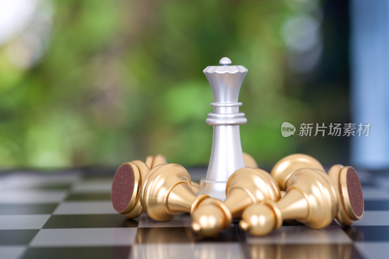 一堆金色兵棋子围绕的银色皇后棋子