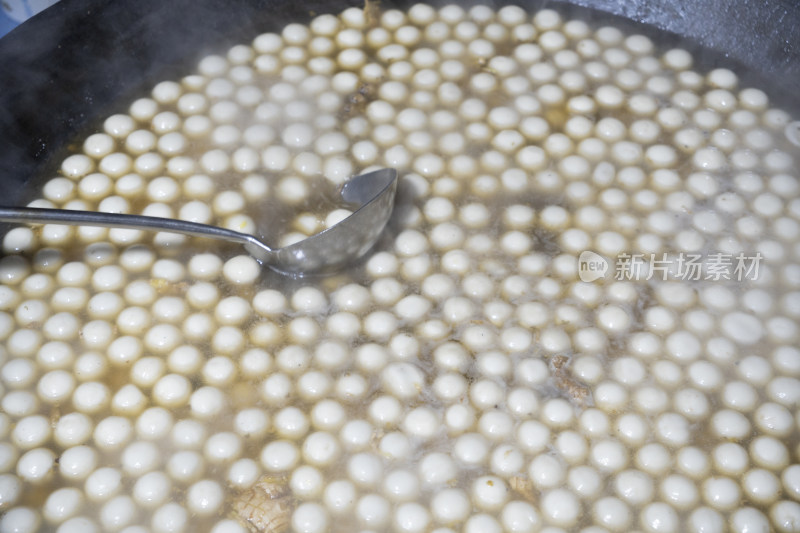 大锅中煮着大量白色汤圆