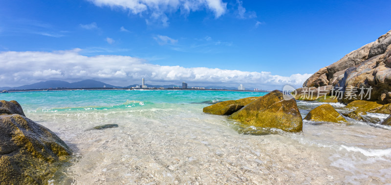 阳光下的海南三亚海岸线上礁石沙滩海浪浪花