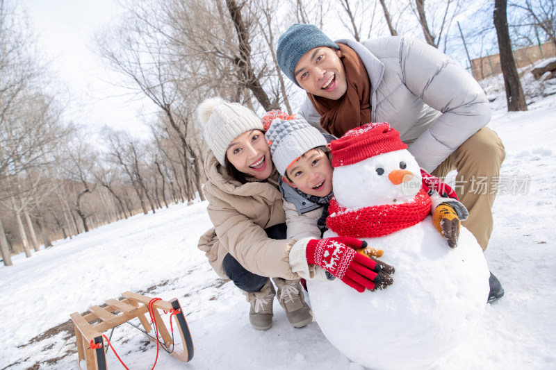 一家三口在雪地里堆雪人