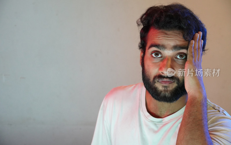 男子单手扶头表情惊讶