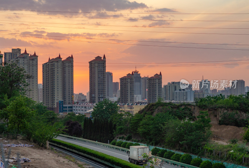 城市黄昏时公路旁的高楼景观