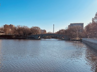 冬日暖阳下的静谧湖景桥梁建筑冰封湖面倒影