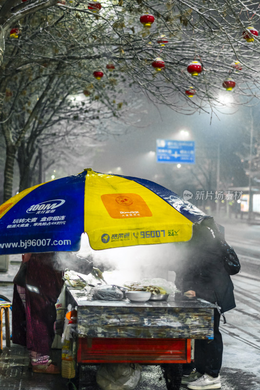 雪夜街边冒着热气的小吃摊