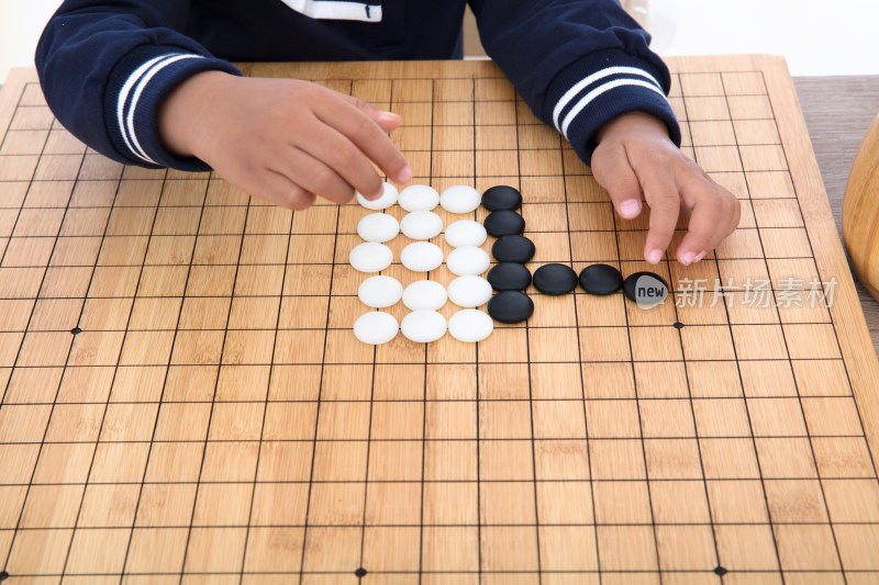 小孩子在棋盘上学习下围棋