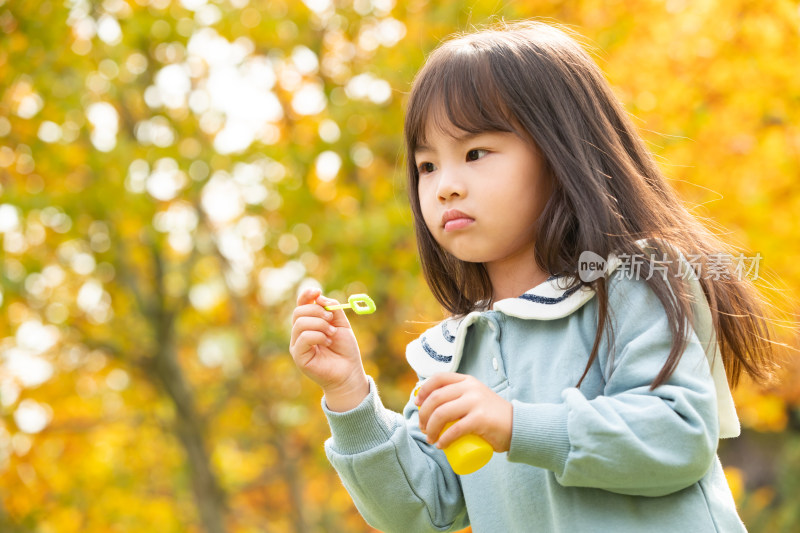 小女孩在公园里吹泡泡