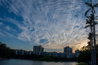 城市湖泊边的多彩天空与林立高楼景致