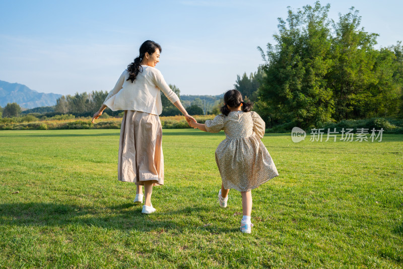 妈妈和女儿在草地上奔跑