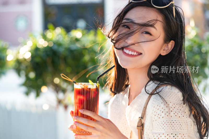 快乐的青年女人拿着夏日饮品