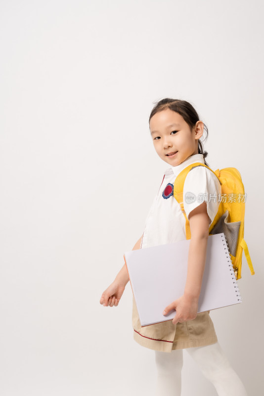 站在白色背景拿着作业本的中国女孩