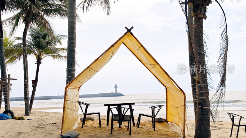 海南三亚海滩上黄色帐篷下的桌椅景观