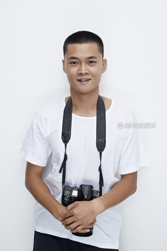 白色背景下手持照相机的亚洲男性摄影师