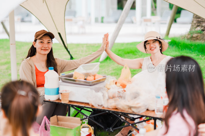 开心享受周末户外野餐幸福时光的亚洲女性