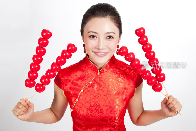 棚拍身穿中国传统服装的年轻女人和糖葫芦