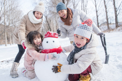 欢乐家庭在雪地里堆雪人