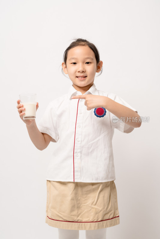 站在白色背景前穿校服喝牛奶的中国女孩