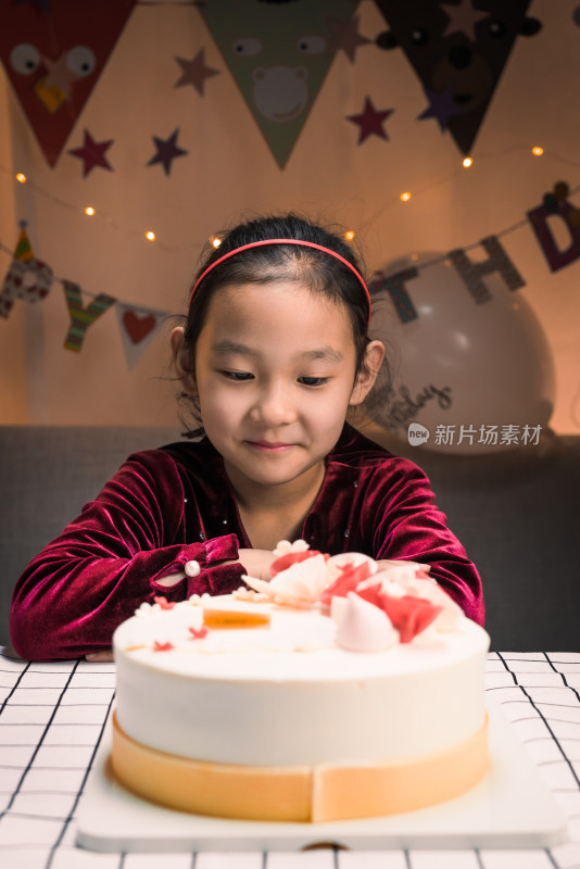 中国女孩凝望着的生日蛋糕