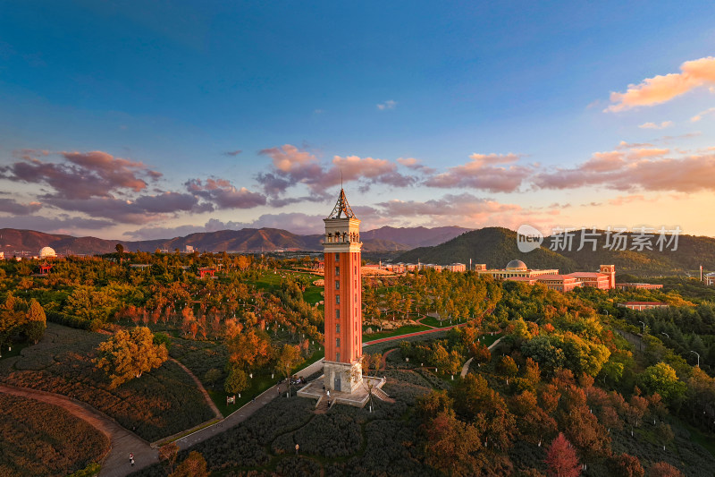 夕阳下的云南大学钟楼景观塔及周边山林全景