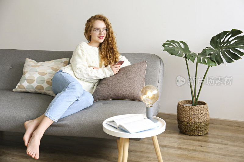 女子居家沙发上玩手机放松