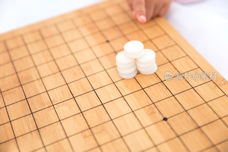 一摞白色棋子在棋盘上