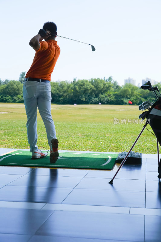 高尔夫练习场上青年男人打高尔夫