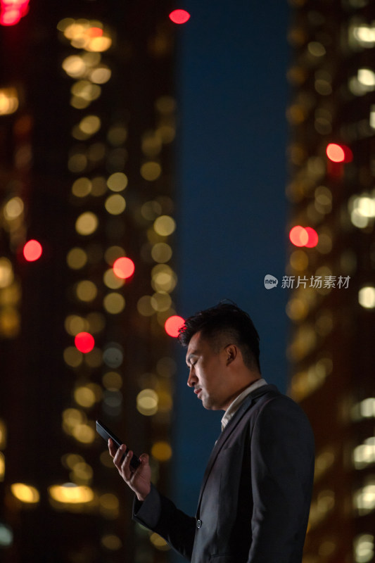 晚上在户外看手机的商务男士