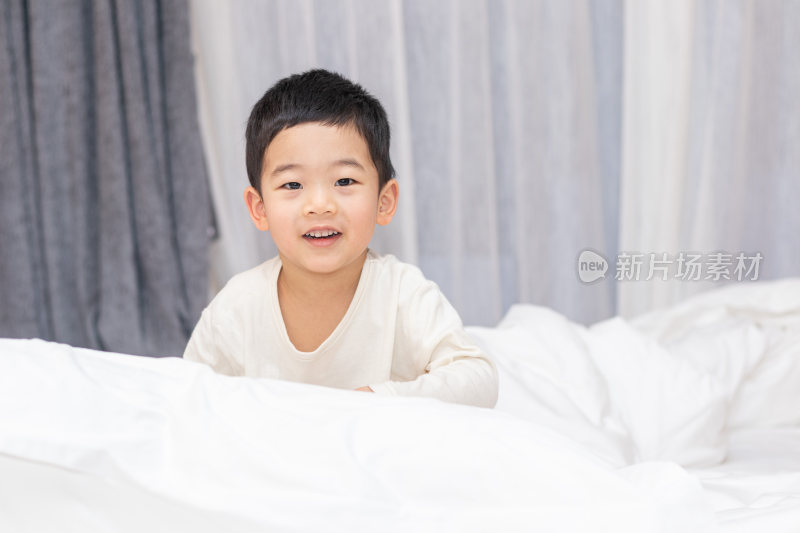 一个小男孩趴在舒适的床上