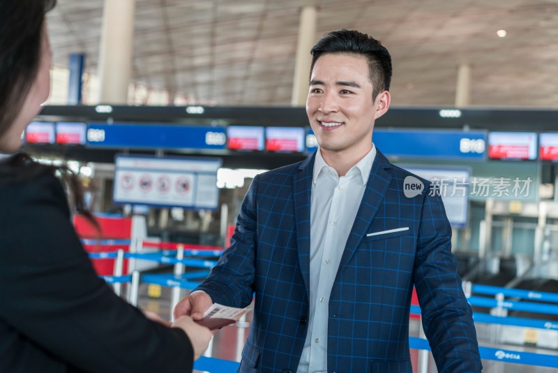 年轻商务男士在机场出示护照