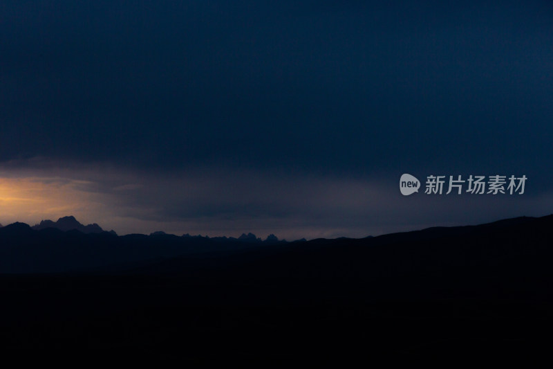 山峰日落时天空映衬的剪影景观