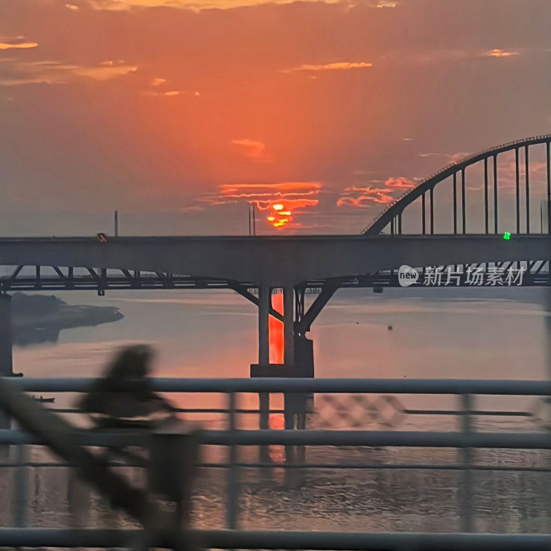 夕阳下的大桥，水面倒映着桥影