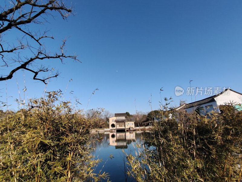 水边房屋与竹林相映成趣的自然景致