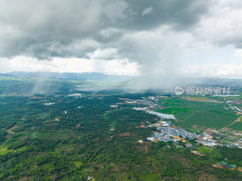 航拍乌云暴雨下的勐海县田园风光