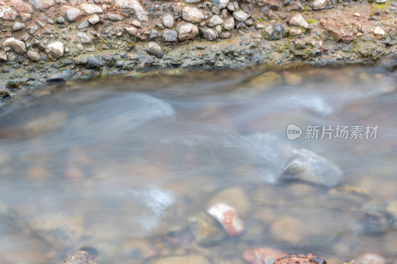 溪边流水潺潺伴石头的自然风光