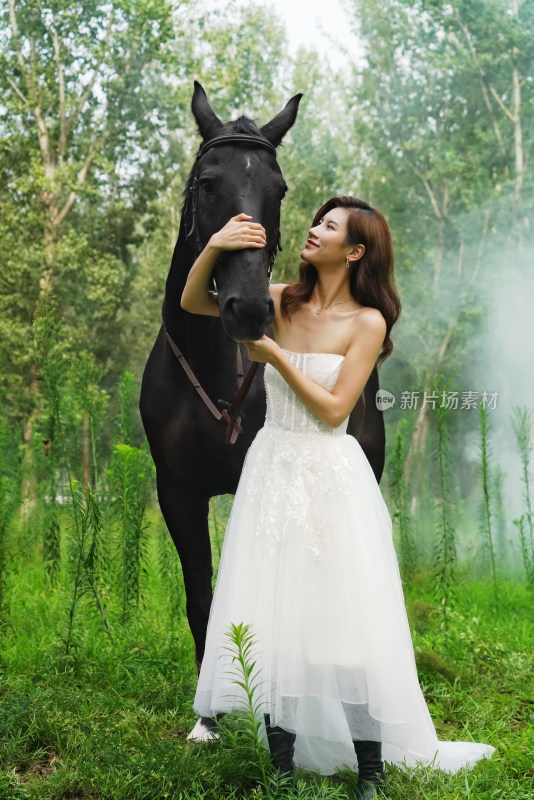 穿婚纱的漂亮女人搂着骏马