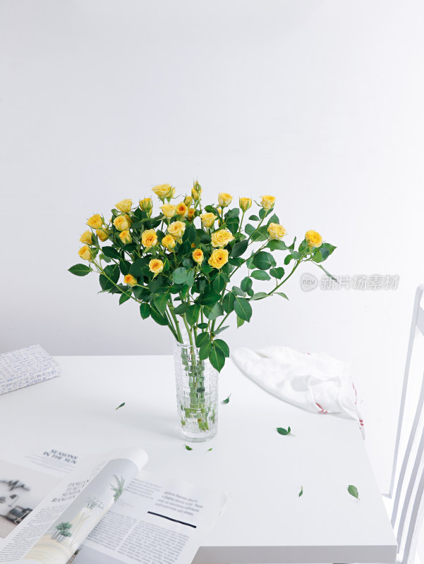 白色桌面上摆放着插好的鲜花玫瑰