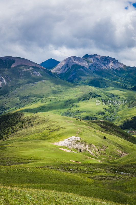 蓝天白云下广袤草原与连绵山峦自然风景