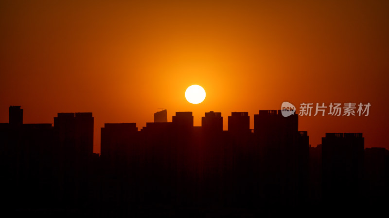 清晨城市高层住宅与日出太阳