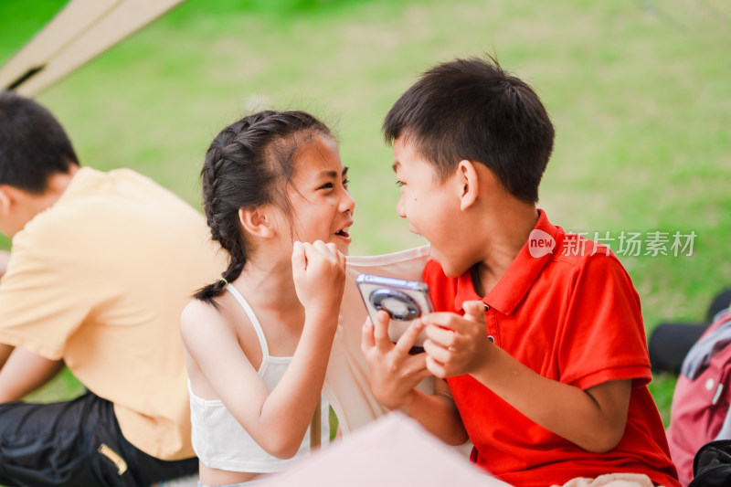 户外公园里草地上开心玩游戏的小男孩小女孩