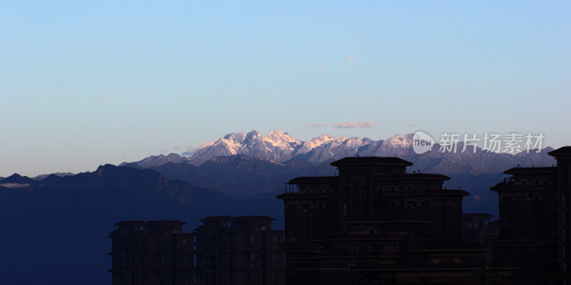 城镇建筑与雪山相映的远景风光