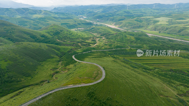 航拍蜿蜒公路穿越绿色山峦的美景