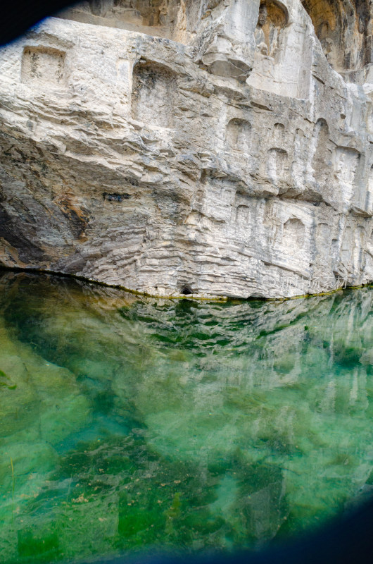 中国河南洛阳龙门石窟的石壁在水中倒影